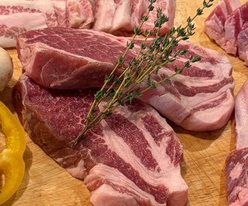 Fresh Berkshire pork cuts arranged on a wooden board